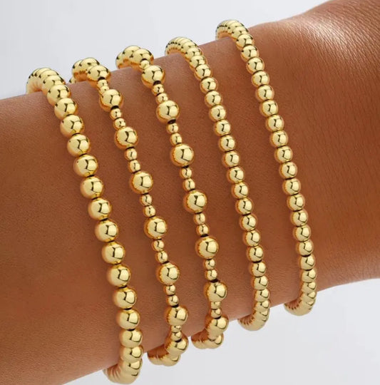 Stack of 5 gold stretch bracelets